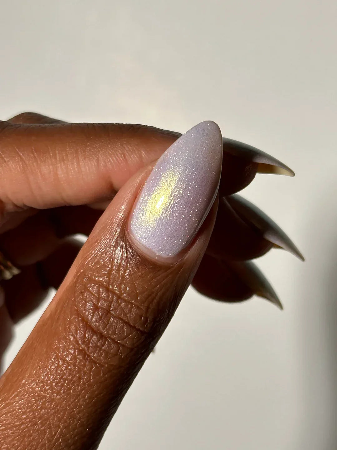 a hand shows off a pearly iridescent nail polish by Death Valley Nails, 10-free non-toxic nail polish available at Luca Essentials in Los Angeles, CA