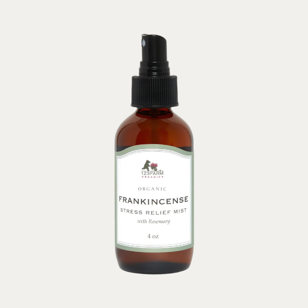 An amber spray bottle of 123 Farm Organic Stress Relief Mist with Rosemary is on a white background. Available at Luca Essentials in Los Angeles.