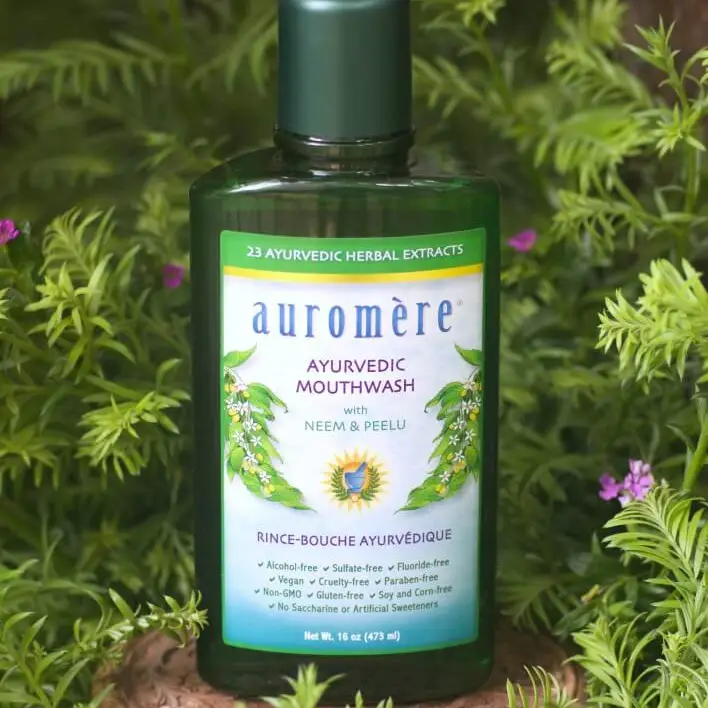 Auromère Ayurvedic Herbal Extracts mouthwash bottle with green label on a natural background. Auromère is available at Luca Essentials in Los Angeles.