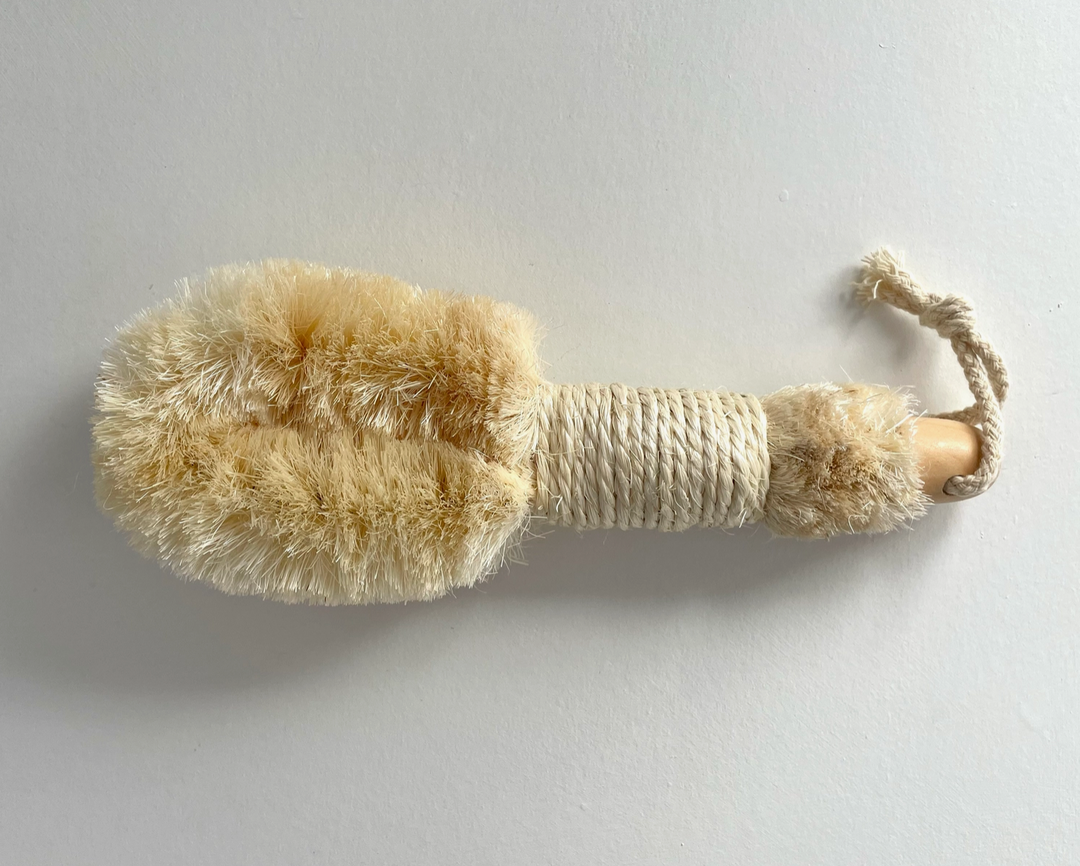 A dry brush on a gray background. Bamboo Switch is available at Luca Essentials in Los Angeles.