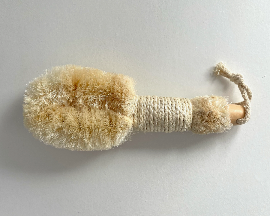 A dry brush on a gray background. Bamboo Switch is available at Luca Essentials in Los Angeles.