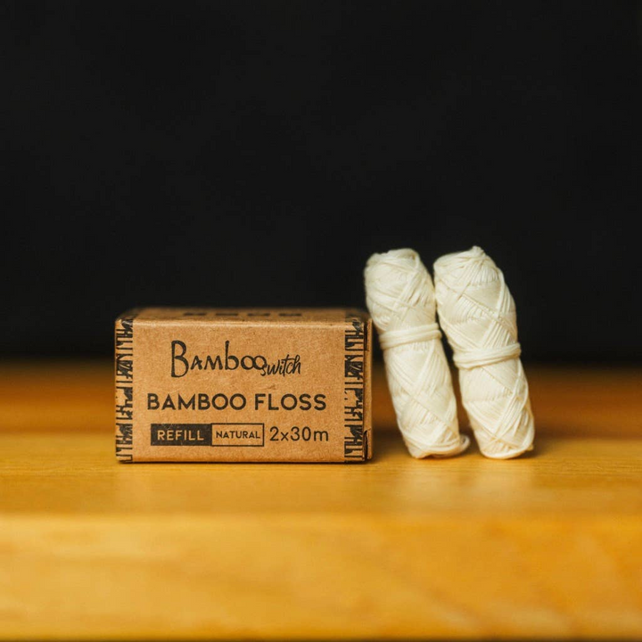 Two rolls of dental floss refills next to their packaging box, which reads 'Bamboo Floss' and has a 'Natural' label. Bamboo Switch is available at Luca Essentials in Los Angeles.