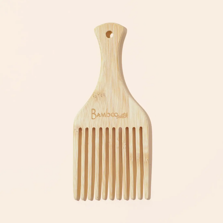 A natural bamboo hair pick with a brand inscription on the handle. Bamboo Switch is available at Luca Essentials in Los Angeles.