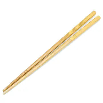 A pair of bamboo chopsticks with a beige and yellow patterned grip. Bamboo Switch is available at Luca Essentials in Los Angeles.