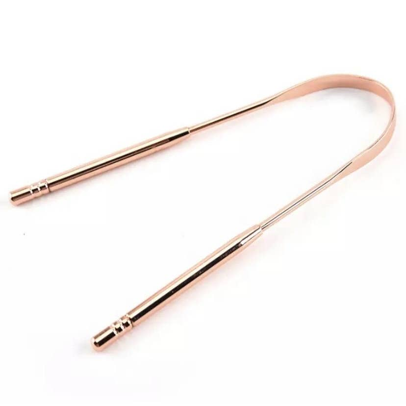 A U-shaped rose gold tongue scraper. Bamboo Switch is available at Luca Essentials in Los Angeles.