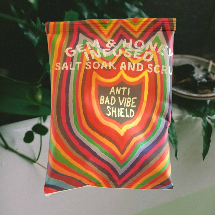 A package of Gem & Honey Infused Salt Soak and Scrub with an image of a rose on the front and the text 'ANTI BAD VIBE SHIELD'. Available at Luca Essentials in Los Angeles. 