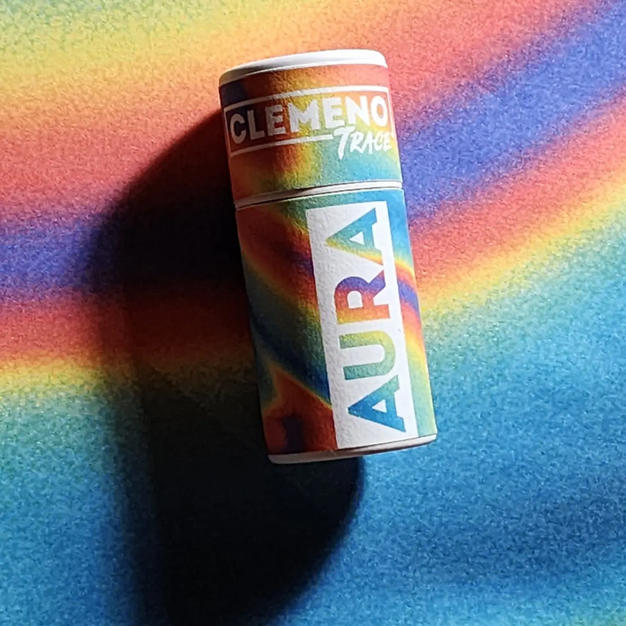 rainbow colored paper tube with the brand name 'clemeno' and the product name 'aura' on a rainbow swirl background. Available at Luca Essentials in Los Angeles. 