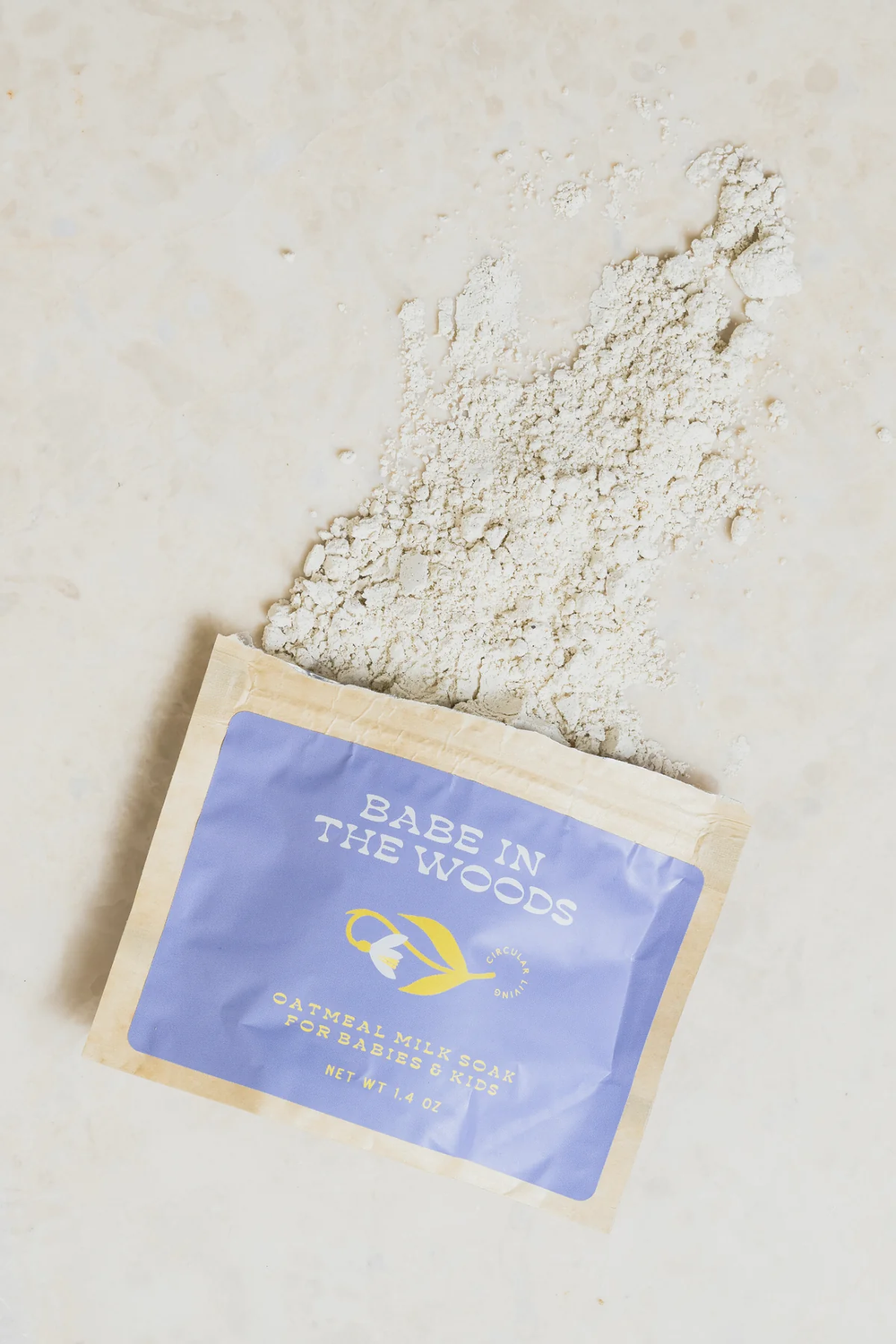 Babe in the Woods oatmeal bath soak with open packaging on a beige surface. Available at Luca Essentials in Los Angeles. 