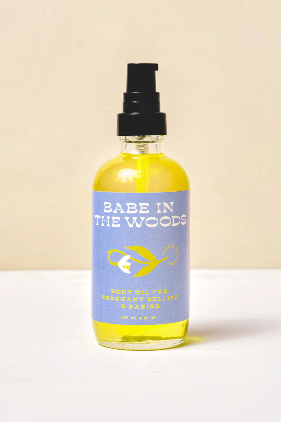 Bottle of 'Babe in the Woods' body oil on a white surface with a beige background. Available at Luca Essentials in Los Angeles. 