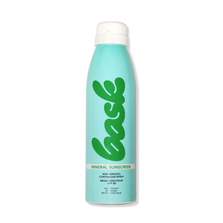Blue sunscreen spray bottle with green logo on a white background. Bask is available at Luca Essentials in Los Angeles.