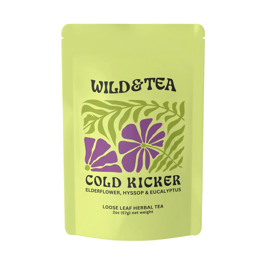 A light yellow-green stand-up pouch of Wild & Tea 'Cold Kicker' loose leaf herbal tea, featuring purple flowers and green leaves on the front, set against a plain white background. Available at Luca Essentials in Los Angeles. 