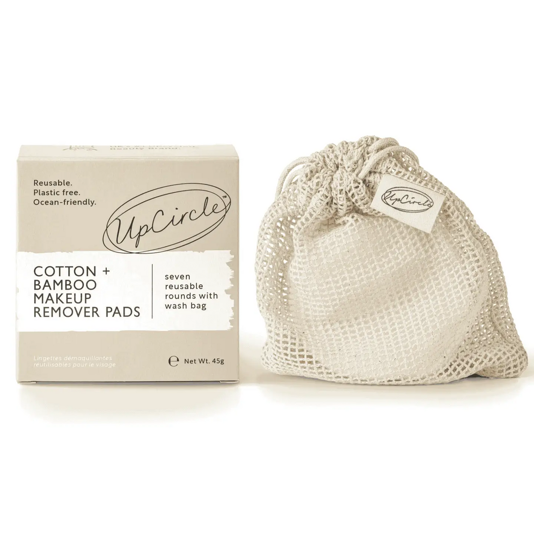 UpCircle reusable cotton and bamboo makeup remover pads shown with their kraft paper box and a beige mesh drawstring wash bag on a white background. Available at Luca Essentials in Los Angeles. 