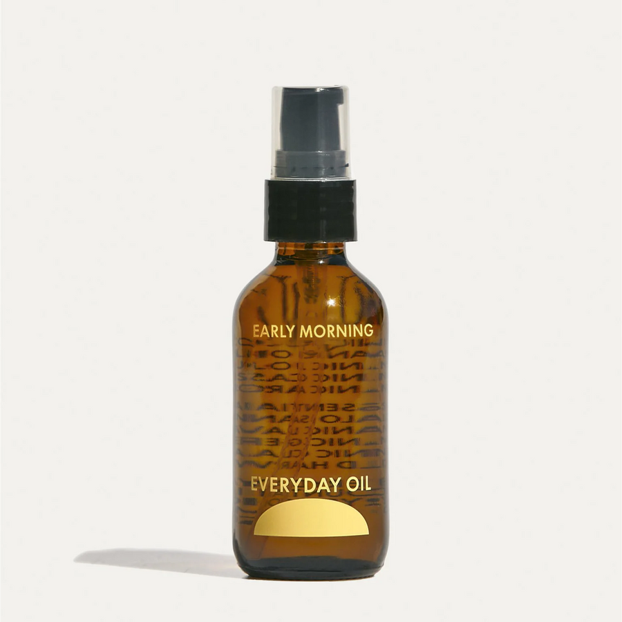 2oz amber bottle of 'Everyday Oil' the branding 'early morning' in yellow with a black pump nozzle on a white background. Available at Luca Essentials in Los Angeles.