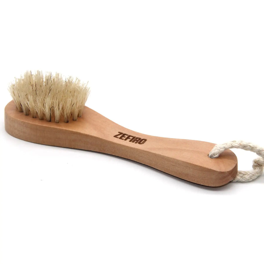 Wooden face brush with bristles and rope handle on a white background. Sold at Luca Essentials in Los Angeles
