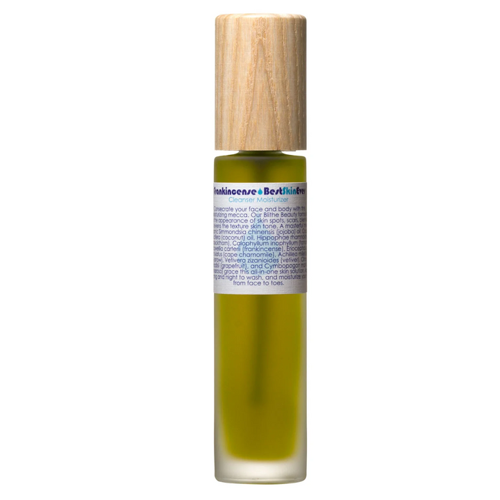 A glass bottle with green liquid and a white label with the title 'Frankincense Best Skin Ever Cleanser Moisturizer' with a wooden lid on a white background. Available at Luca Essentials in Los Angeles. 