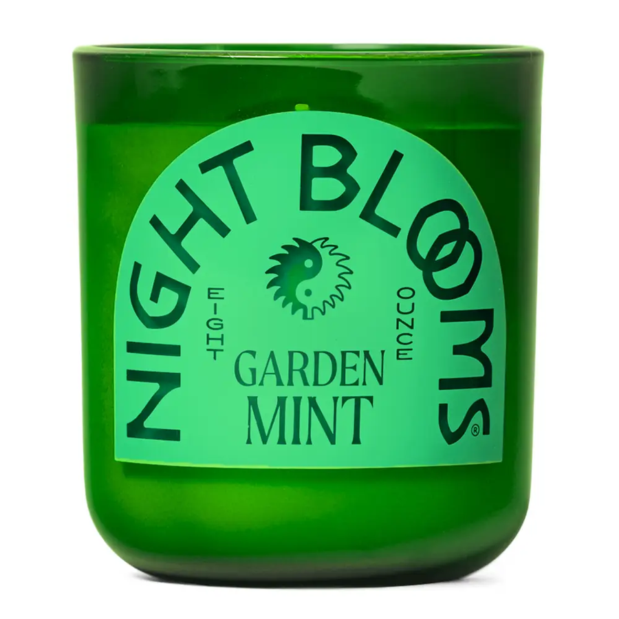 Green candle with 'Night Blooms' and "Garden Mint" label on a white background. Available at Luca Essentials in Los Angeles. 