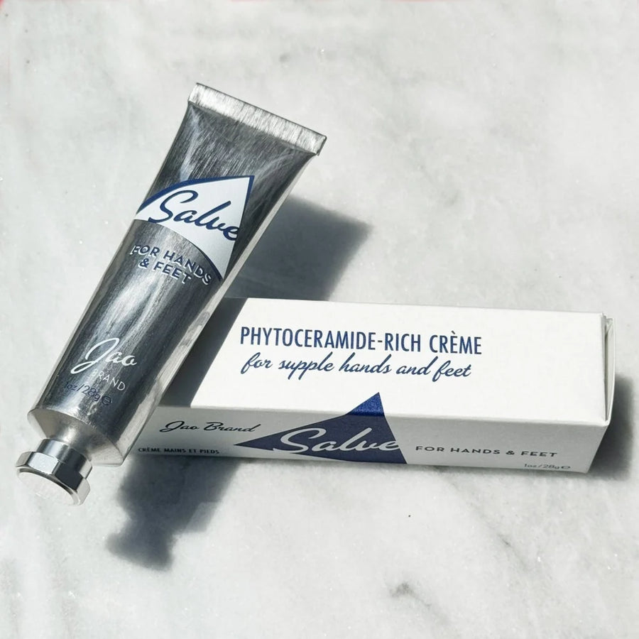 Tube and packaging of Salve for Hands & Feet Phytoceramide-Rich Crème on a marble surface. Sold at Luca Essentials in Los Angeles