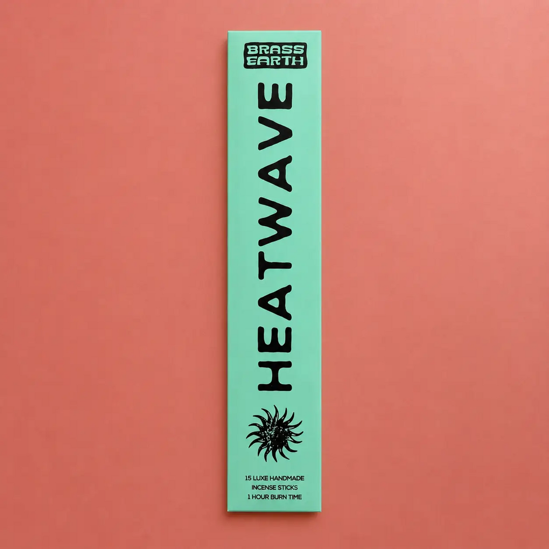 Green package of Heatwave incense sticks by Brass Earth on a red background. Available at Luca Essentials in Los Angeles. 