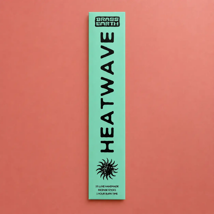Green package of Heatwave incense sticks by Brass Earth on a red background. Available at Luca Essentials in Los Angeles. 