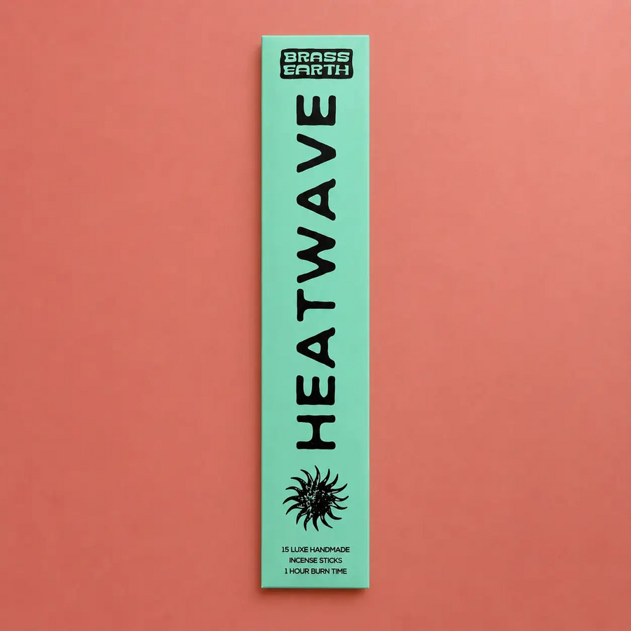 Green package of Heatwave incense sticks by Brass Earth on a red background. Available at Luca Essentials in Los Angeles. 