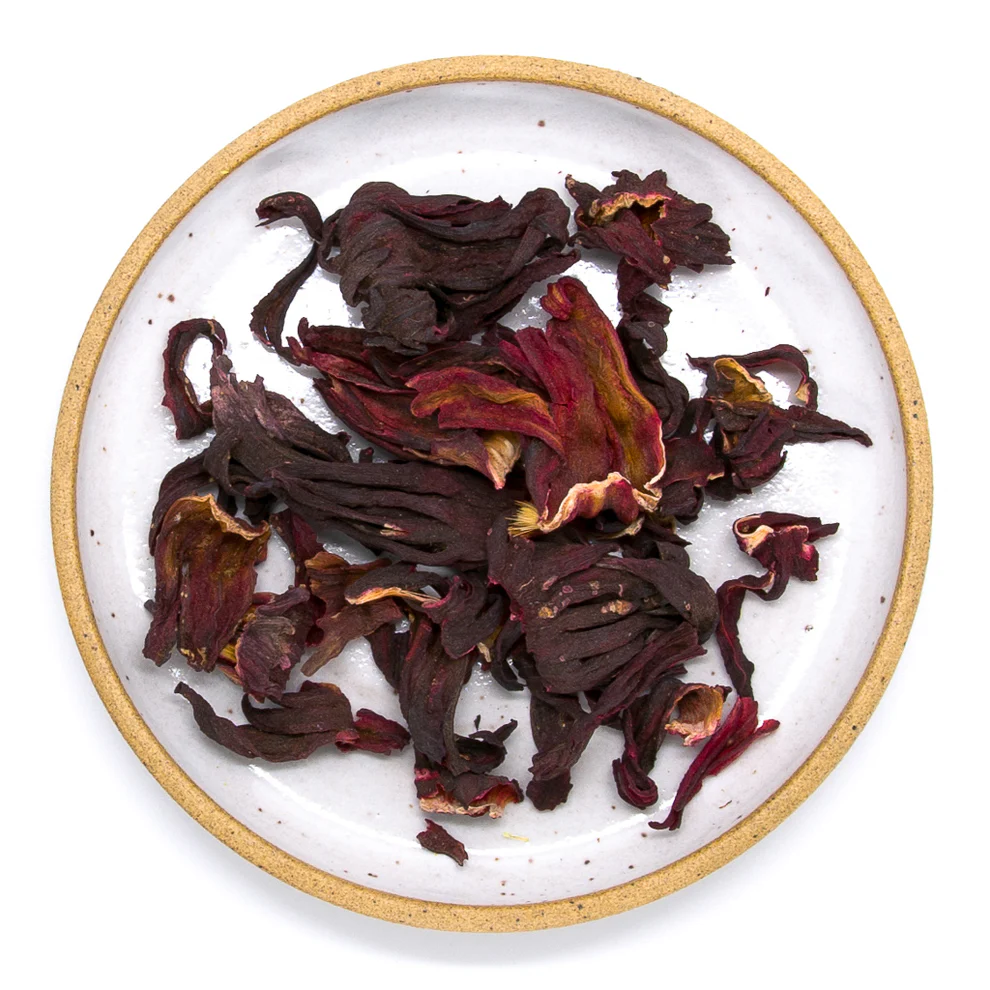 Dried hibiscus flowers on a white plate with a gold rim. Available at Luca Essentials in Los Angeles. 