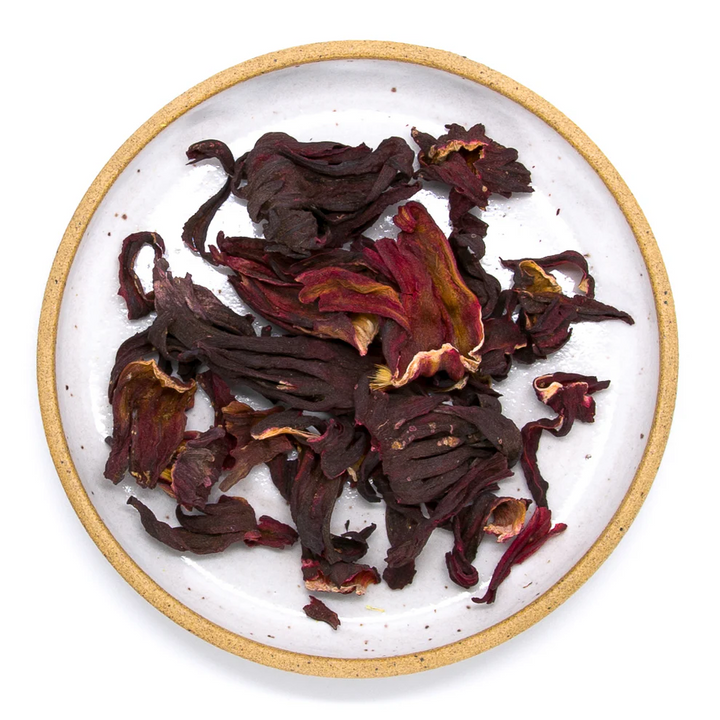 Dried hibiscus flowers on a white plate with a gold rim. Available at Luca Essentials in Los Angeles. 