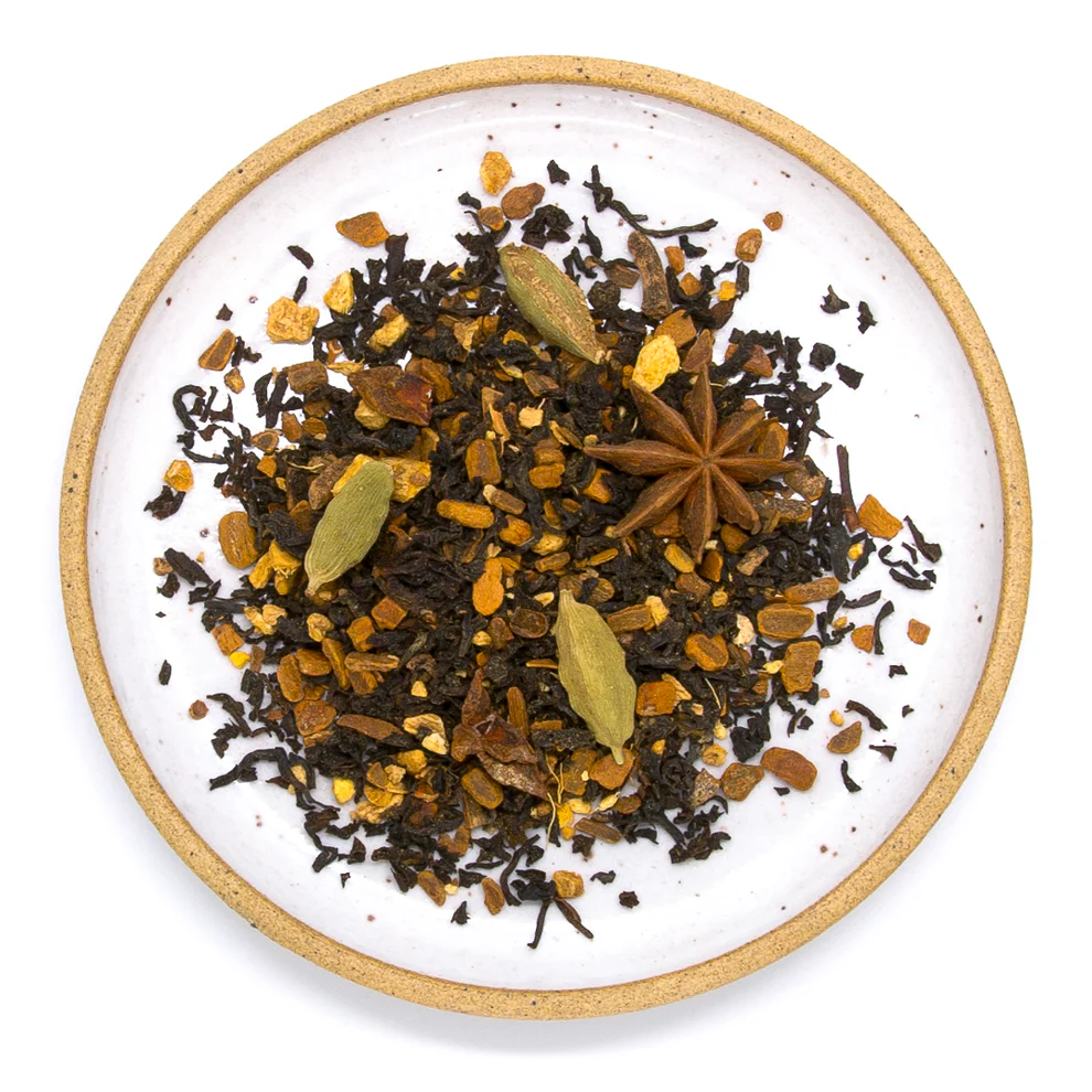 Spice mix including star anise and cardamom on a white plate with a gold rim. Available at Luca Essentials in Los Angeles. 