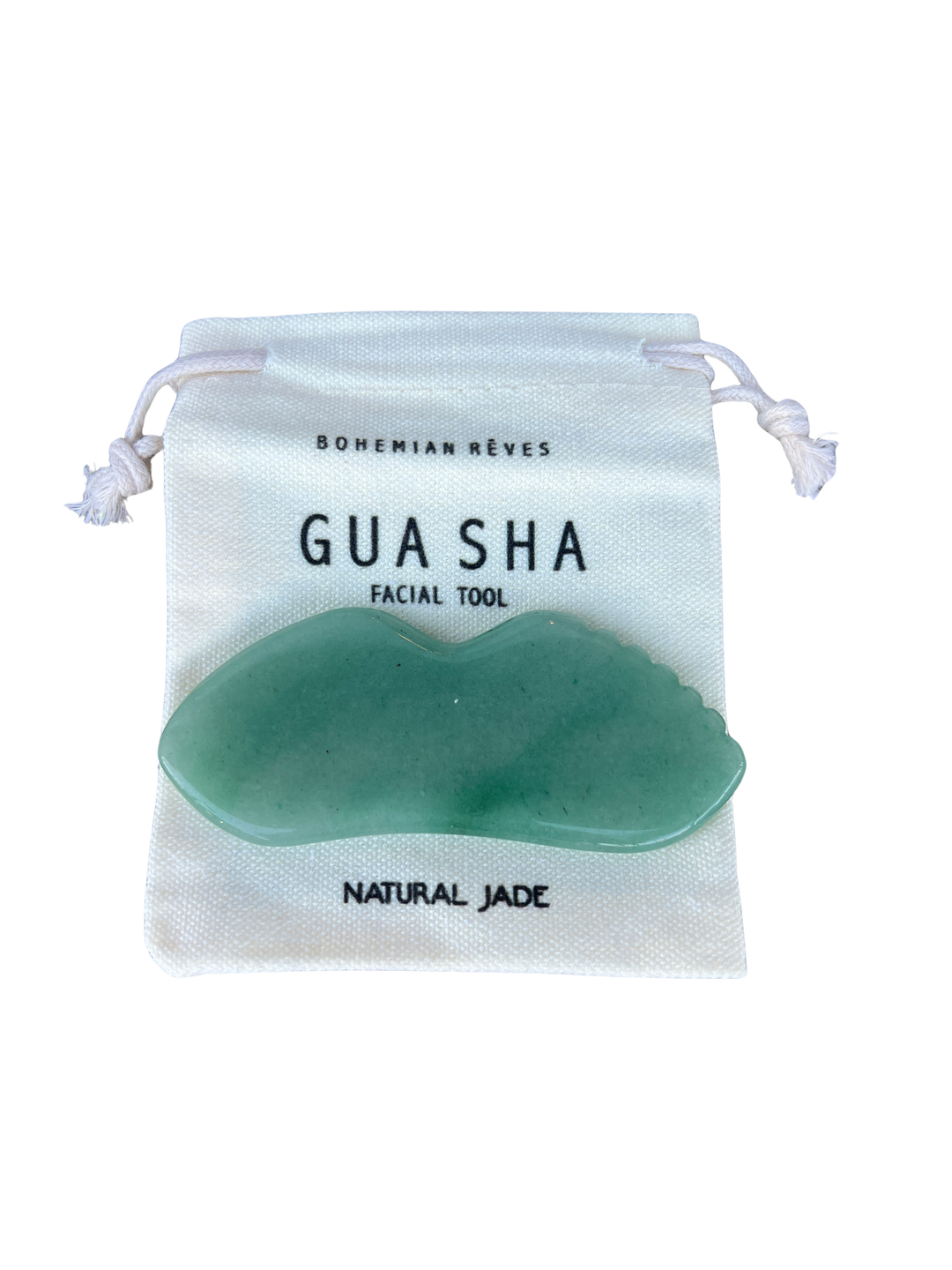 green jade gua sha tool on a branded pouch with 'bohemian reves'. Available at Luca Essentials in Los Angeles. 