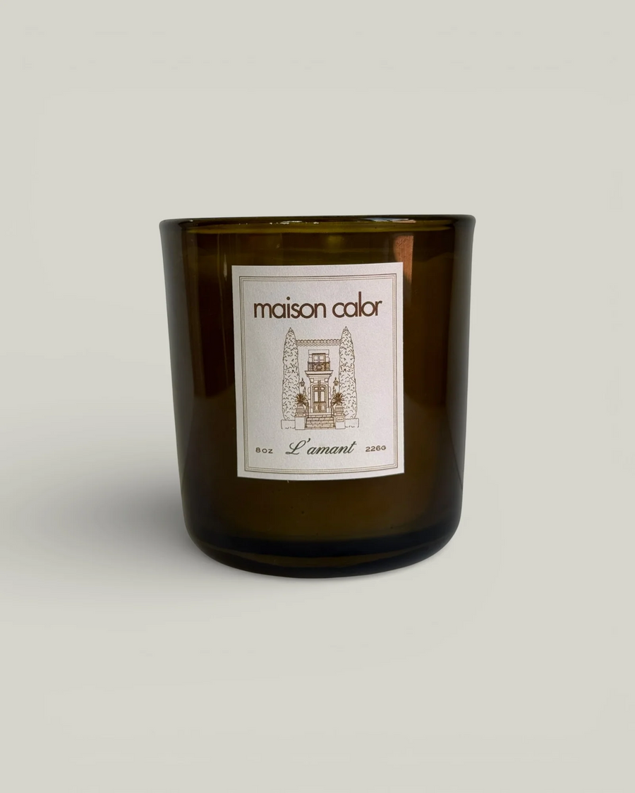 dark green glass candle container with the brand name 'maison calor' on a white sticker on a white background. Available at Luca Essentials in Los Angeles. 