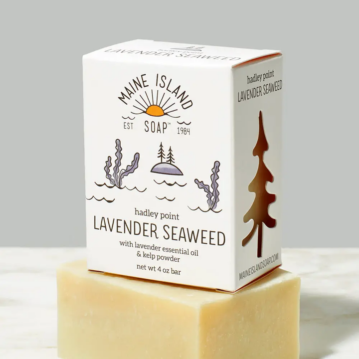 A bar of Maine Island Soap 'Hadley Point Lavender Seaweed' with an illustration of seaweed and water on top of a beige/yellow bar soap without packaging. Available at Luca Essentials in Los Angeles. 