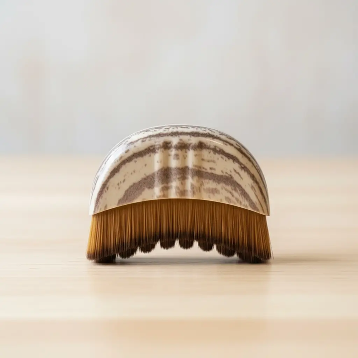 Facial dry brush with brown bristles on a light background. 

This palm sized facial dry brush is designed to gently stimulate the skin, support natural lymphatic wellness, and encourage a more lifted, sculpted appearance.

Available at Luca Essentials in Los Angeles. 
