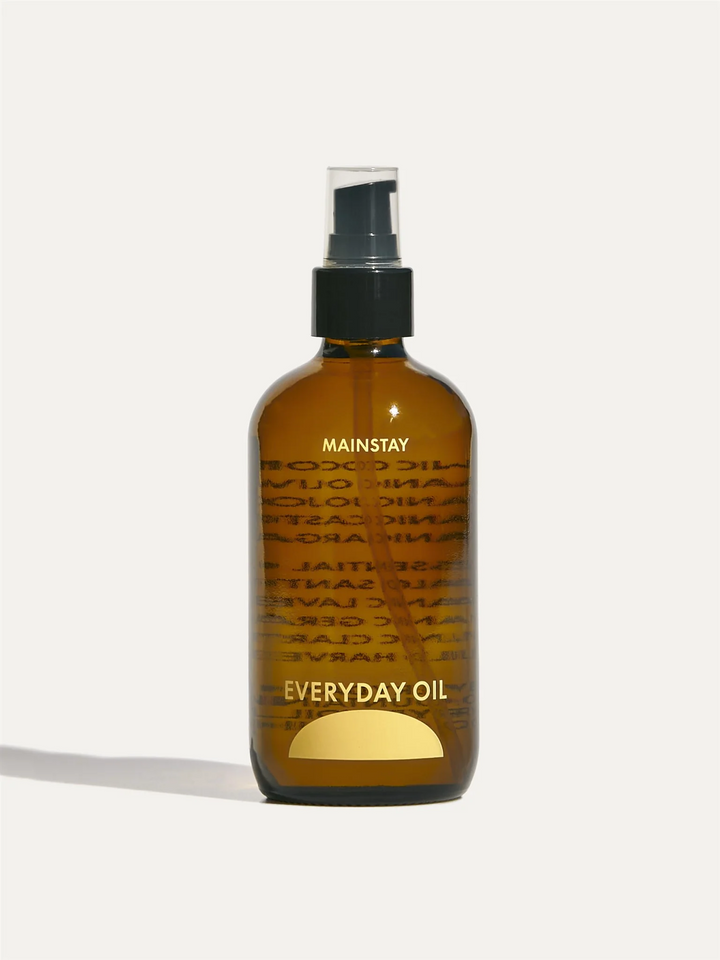 8oz amber bottle of everyday oil with yellow logo and label and the name 'mainstay' above the name 'everyday oil' with a half moon underneath. Black pump top with plastic lid. Available at Luca Essentials in Los Angeles. 