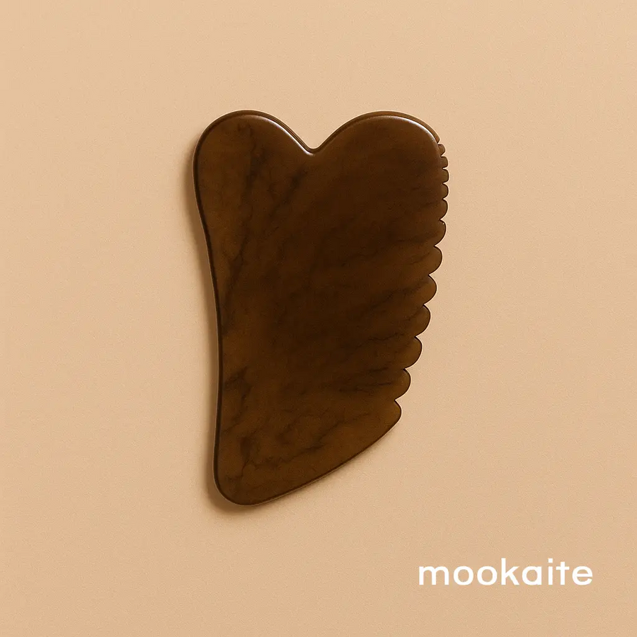 Brown Gua Sha tool on a beige background with 'mookaite' branding. Available at Luca Essentials in Los Angeles. 