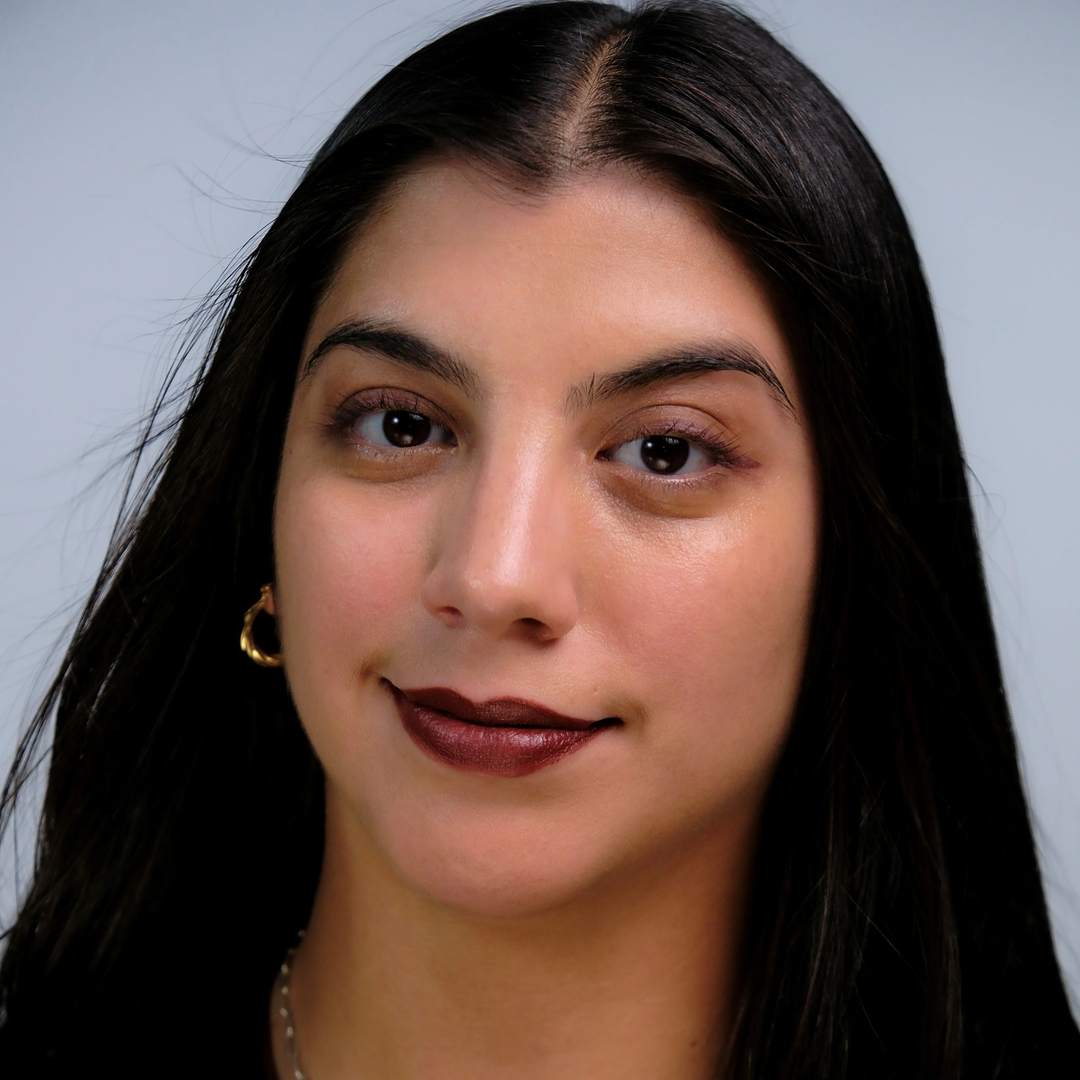 Moonstone- Close-up of a medium-tan skin toned person with long dark hair against a plain background. Available at Luca Essentials in Los Angeles. 