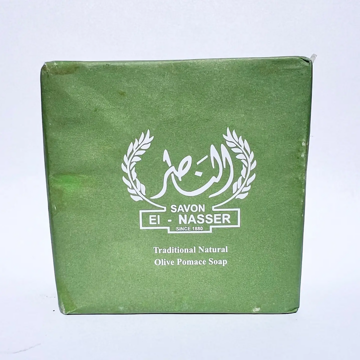 A square green box of Savon El Nasser Traditional Natural Olive Pomace Soap, featuring a white printed logo and text on a plain white background. Available at Luca Essentials in Los Angeles. 