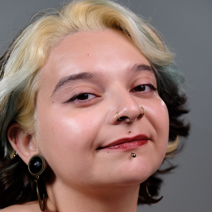 Opal- Close-up of a person a light skin tone with styled hair and visible jewelry against a neutral background. Available at Luca Essentials. 
