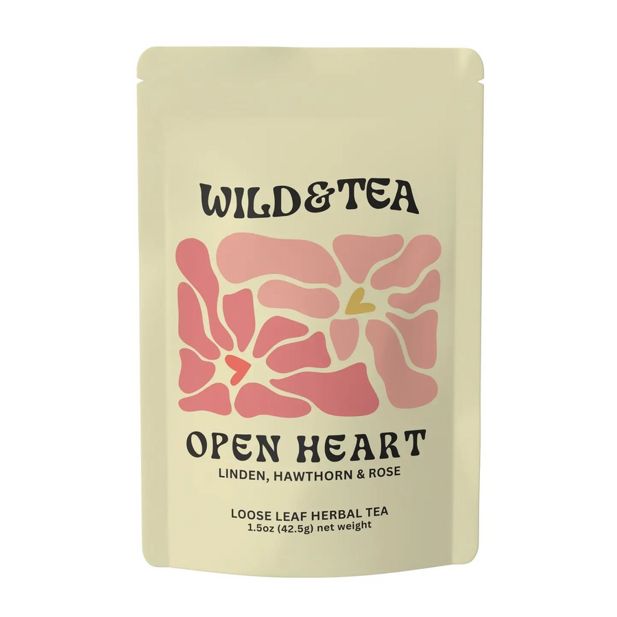 A light yellow stand up bag of Wild & Tea 'Open Heart' herbal tea with a pink floral design on a white background. Available at Luca Essentials in Los Angeles. 