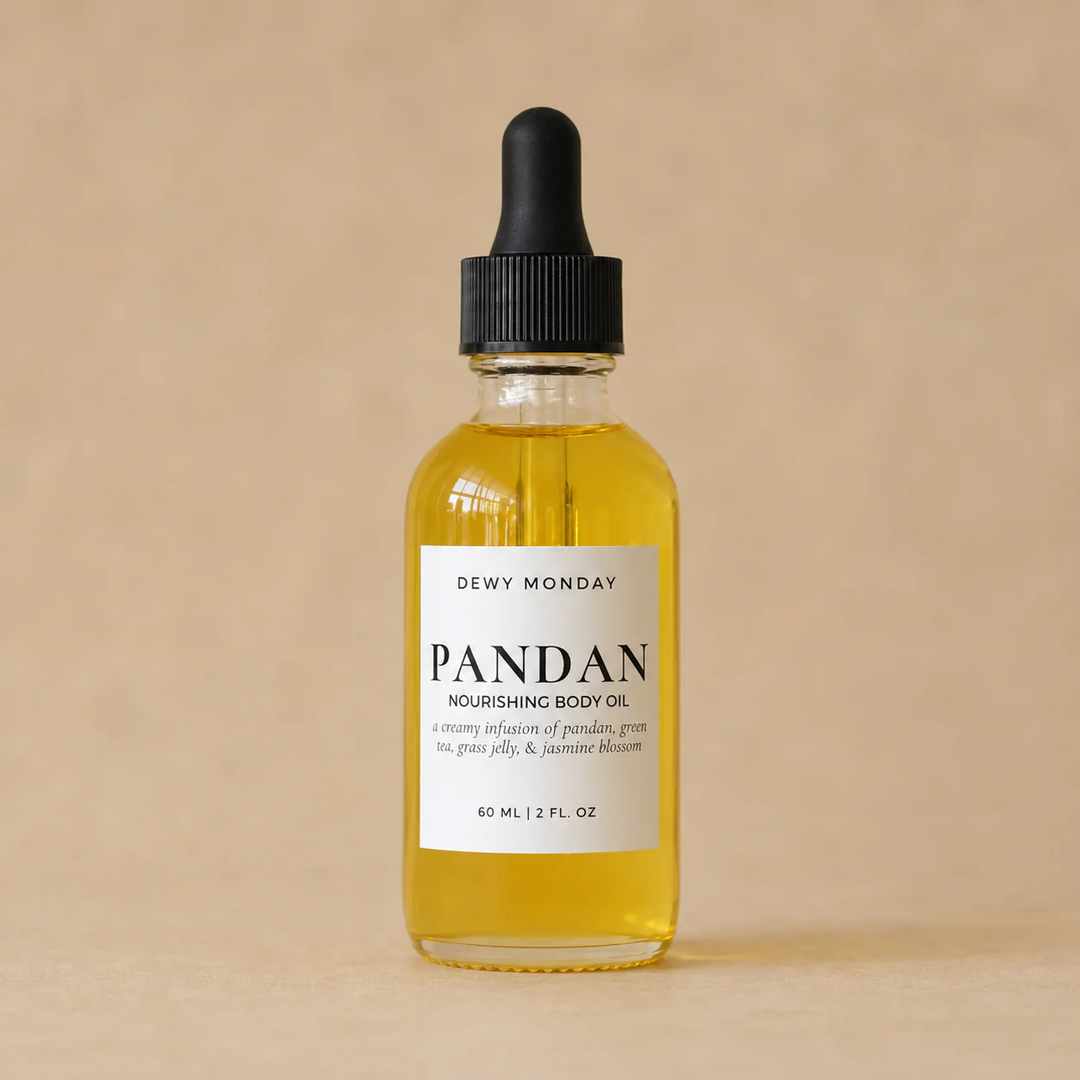 Bottle of Dewy Monday Pandan nourishing body oil on a beige background. Available at Luca Essentials in Los Angeles. 