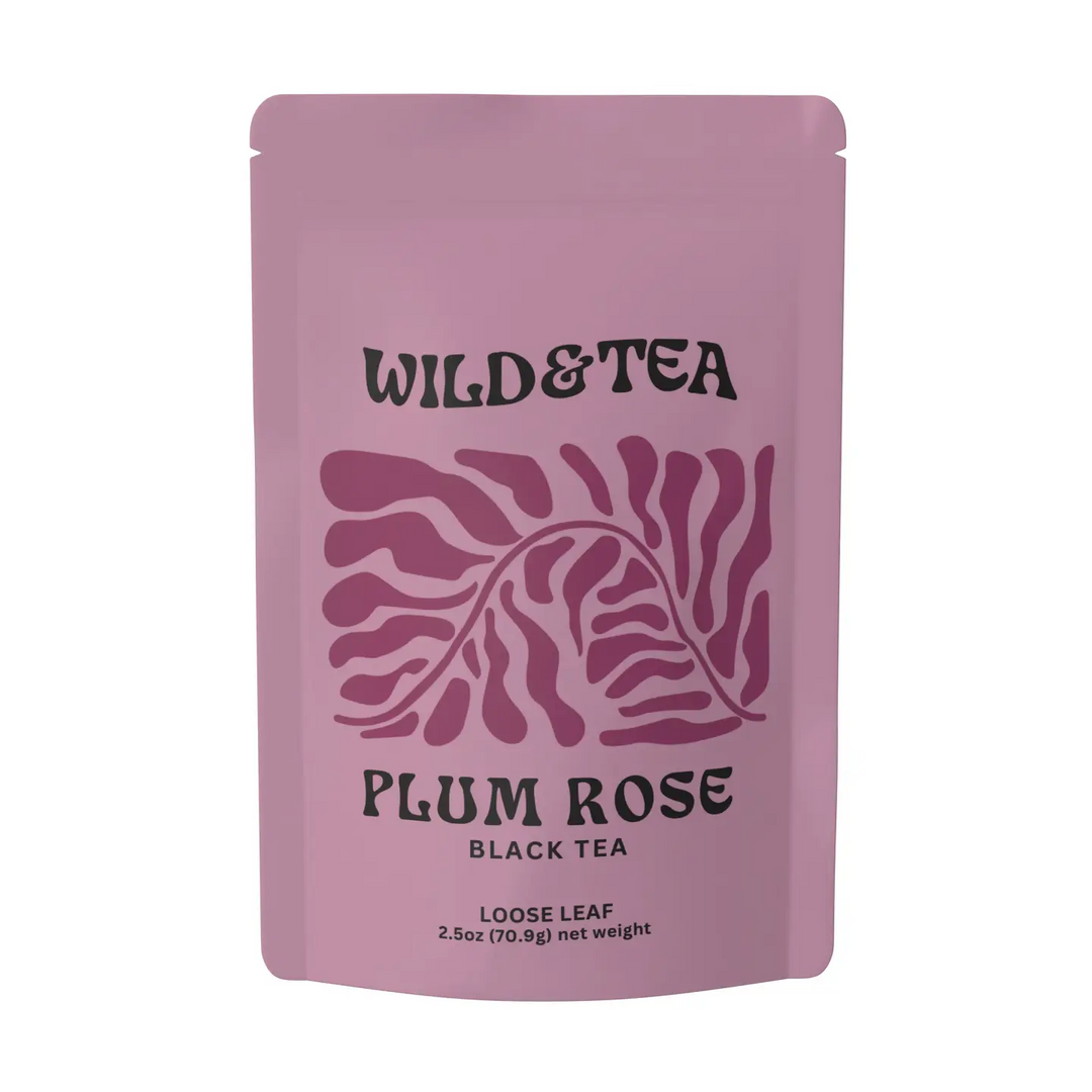 mauve package of tea with the brand name 'wild & tea' and a dark purple leaf illustration and the product title 'Plum Rose Black Tea" on a white background. Available at Luca Essentials in Los Angeles. 