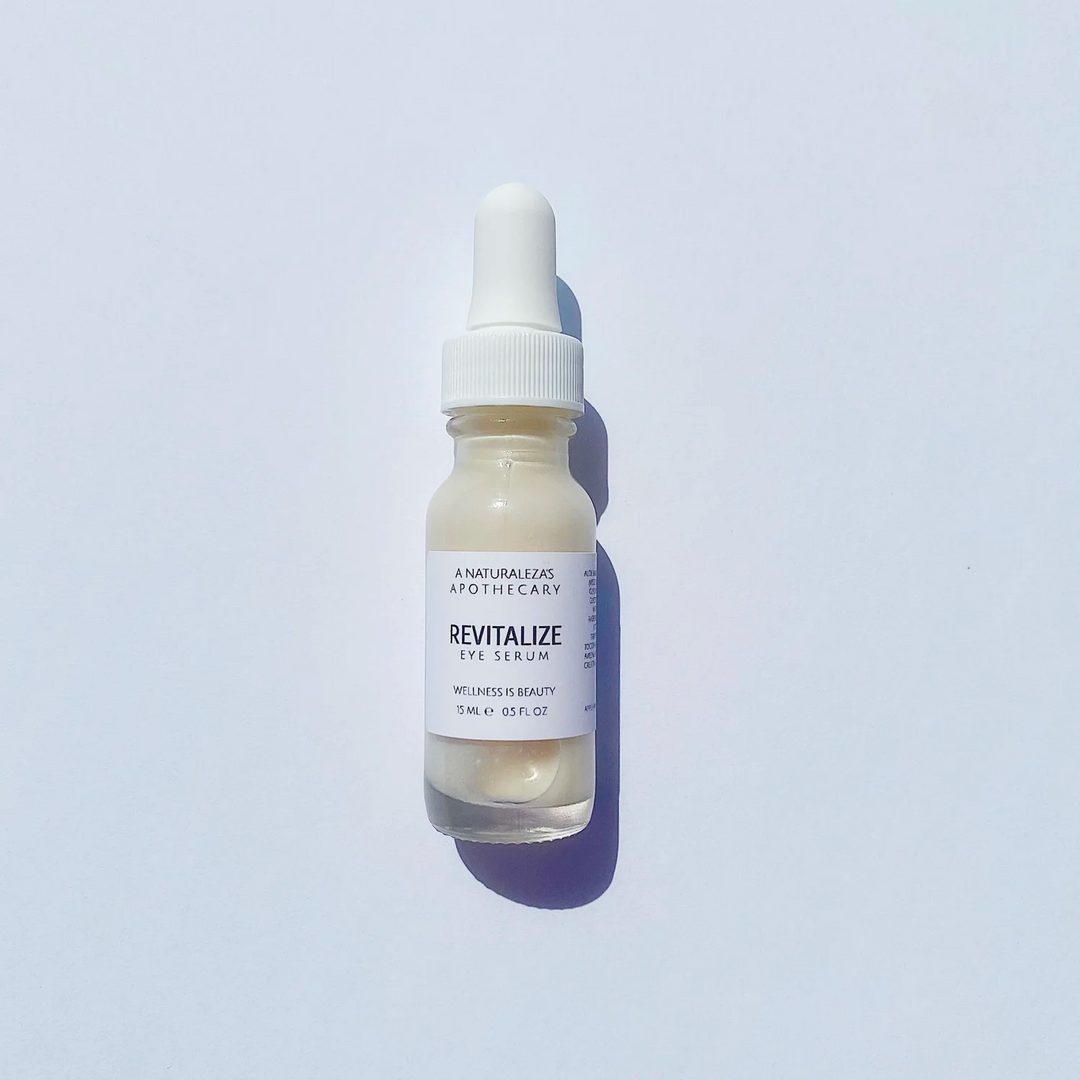 Skincare serum bottle with the word "revitalize" on the outside with dropper on a light gray background. Available at Luca Essentials in Los Angeles. 