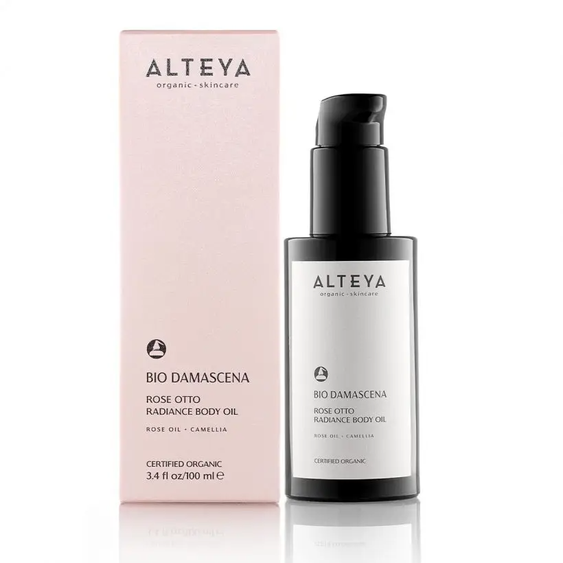 Pink box with the brand name 'alteya' and the product name 'bio damascena rose otto radiance body oil' next to a black pump bottle with a white label on a white background. Available at Luca Essentials in Los Angeles. 