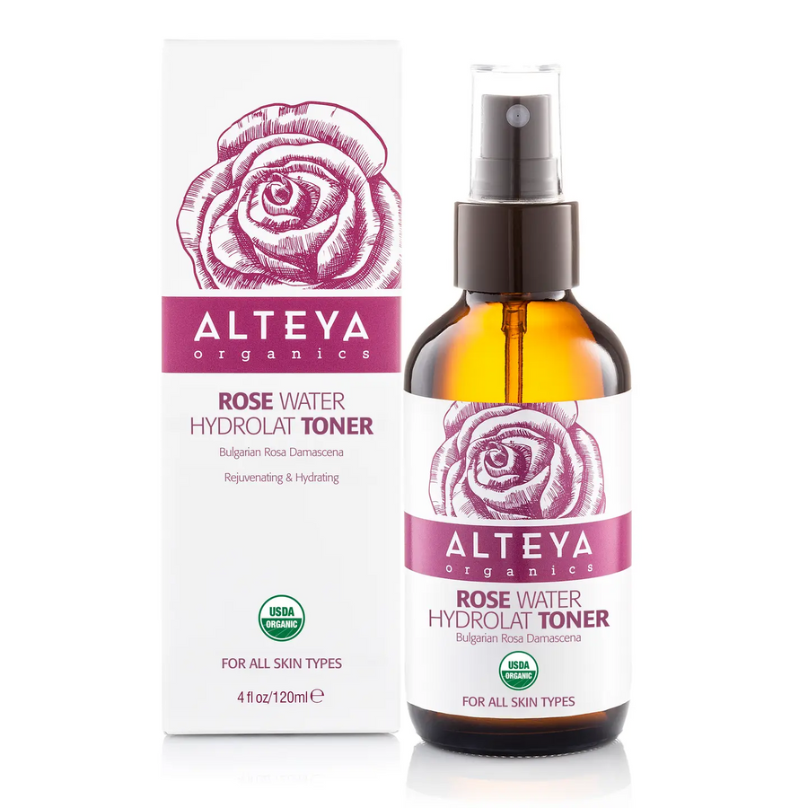 Alteya Organics Rose Water Hydrolat Toner shown as an amber glass spray bottle next to its white and magenta packaging box, on a clean white background. Available at Luca Essentials in Los Angeles. 