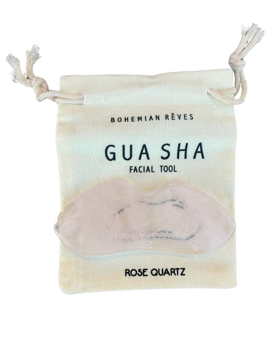 Rose quartz guasha facial tool in a drawstring bag with 'Bohemian Rèves' branding. Available at Luca Essentials in Los Angeles. 