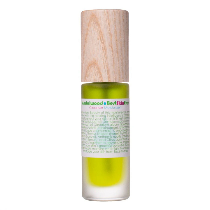 A clear glass bottle with a wooden cap, filled with a green liquid, labeled as 'Sandalwood Best Skin Ever' serum. Available at Luca Essentials in Los Angeles. 