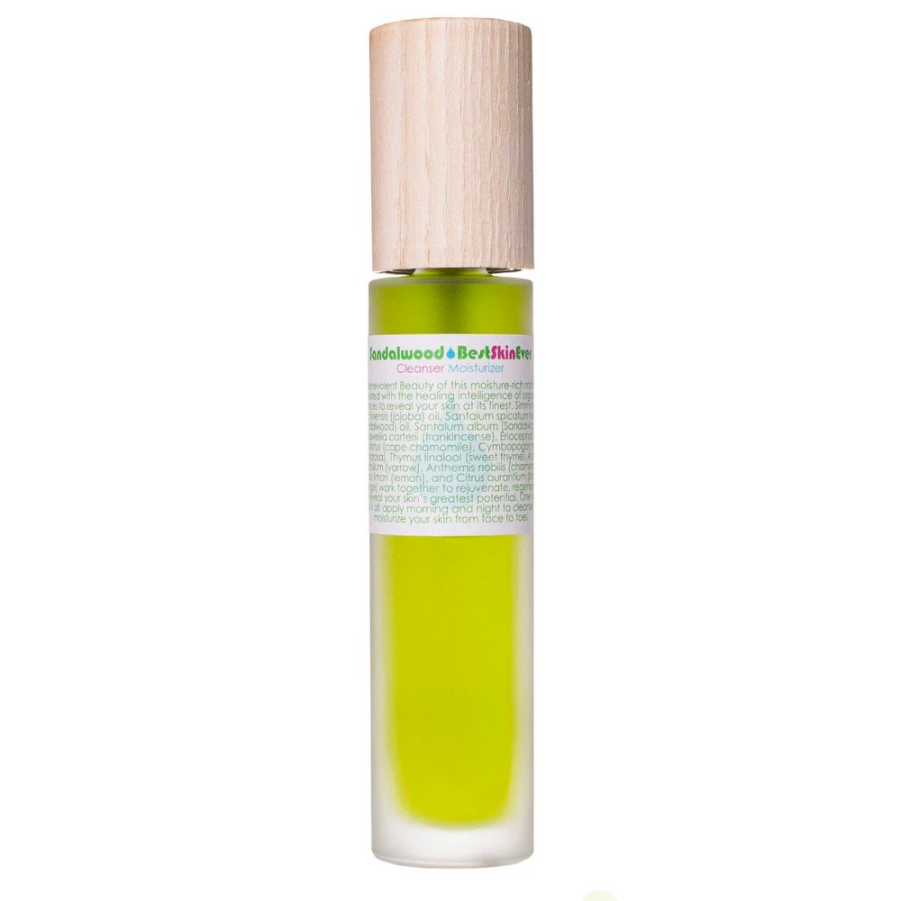 A clear glass bottle with a wooden cap, filled with a green liquid, labeled as 'Sandalwood Best Skin Ever' serum. Available at Luca Essentials in Los Angeles. 