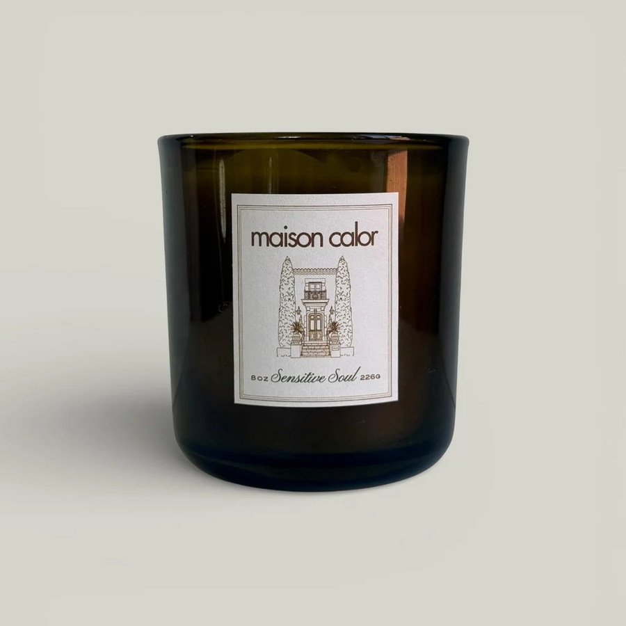 Image depicting a Maison Calor candle with the scent Sensitive Soul in a dark green glass container on a white background. Available at Luca Essentials in Los Angeles. 