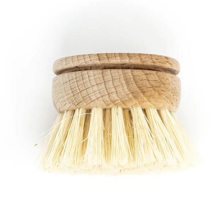 A bamboo dish brush replacement head with. a cut out in the top and sisal fibers in clumps at the end. Available at Luca Essentials in Los Angeles. 