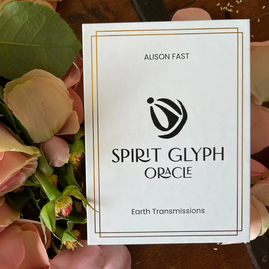 a white box of oracle cards with the title 'spirit glyph oracle' on a background of roses. Available at Luca Essentials in Los Angeles. 