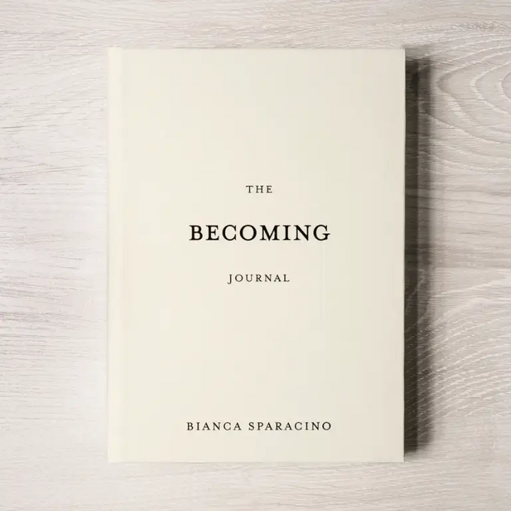 Book titled 'The Becoming Journal' by Bianca Sparacino on a wooden surface. Available at Luca Essentials in Los Angeles. 