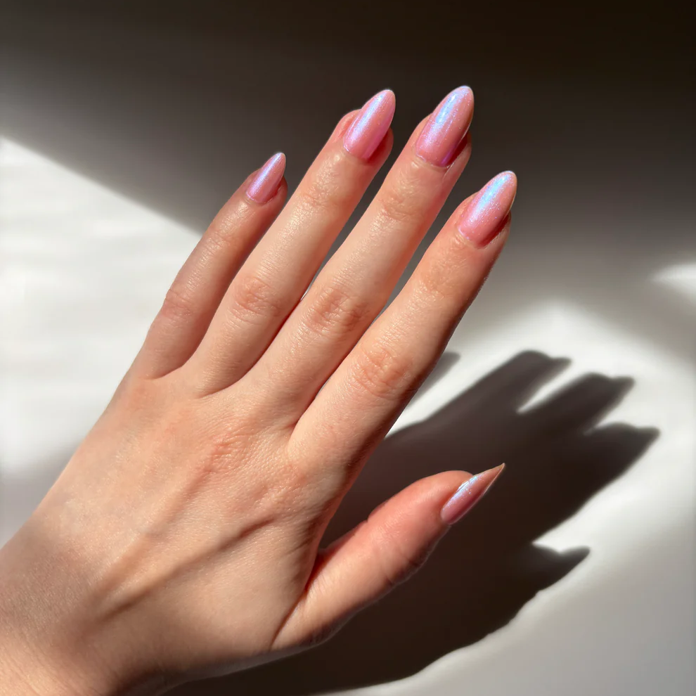 Hand with pink nail polish on a light background. Available at Luca Essentials in Los Angeles. 
